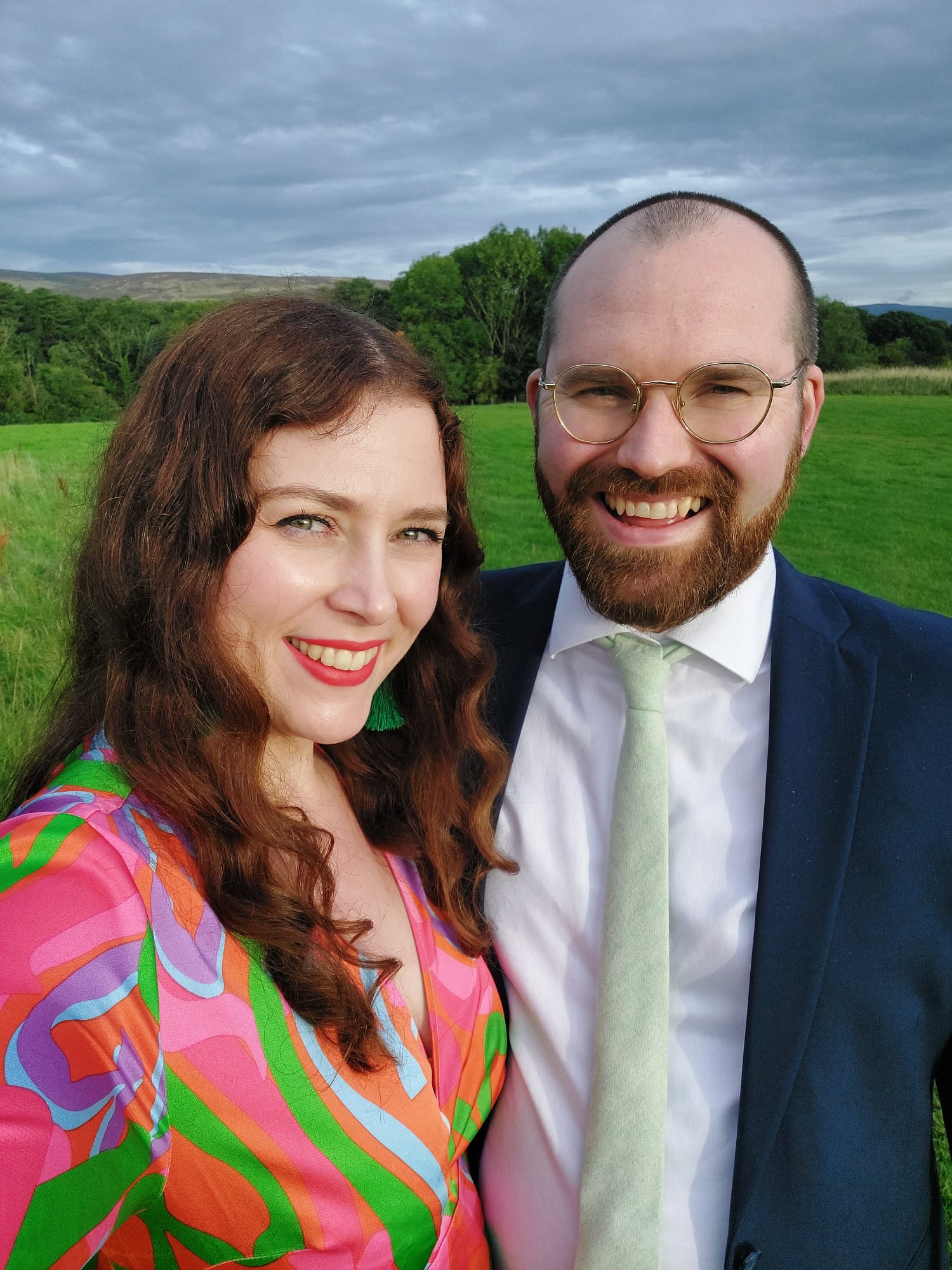 Laura & Bob dressed smart with a countryside backdrop
